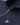 Close-up of a Belstaff Quarter Zip Sweatshirt, Dark Ink blue, featuring a silver metal zipper, a stand-up collar, and the signature gold winged 'B' logo patch on the chest.