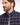 A close-up side profile of a man with a beard wearing a Eden Park Check Shirt, Navy & Brown in navy, brown, and white.