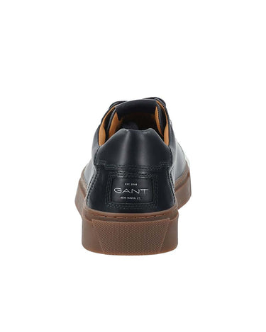 A single GANT sneaker shown from the rear, featuring a black leather upper with a tan interior lining and a brown textured rubber sole, on a solid white background.