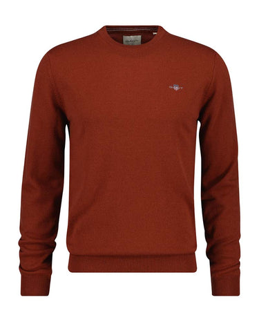 A rust-colored GANT Lambswool Crew Neck Jumper Copperwood sweater with a small embroidered logo on the left chest, displayed on a clean white background.