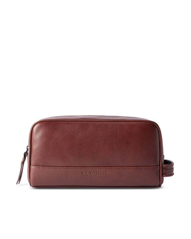 A R.M. Williams Farrier Washbag, Whiskey Brown with a zippered closure and a small embossed brand name on the front, shown against a plain white background.