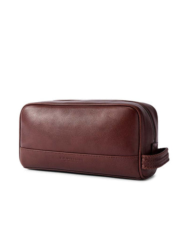 A R.M. Williams Farrier Washbag, Whiskey Brown with a zippered closure and a braided handle, shown on a plain white background.