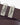 Close-up of a R.M. Williams Slim Drover Belt, Chestnut with polished silver-tone metal buckles engraved with the R.M. Williams brand name and logo.