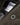 Close-up of an Strellson Padded Light Jacket, Beige green with a silver cross-shaped metal emblem on the chest and a visible Strels brand tag inside the zipper.