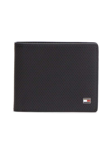 A black Tommy Hilfiger bi-fold wallet with a perforated leather texture and the signature Tommy Hilfiger flag logo patch on the bottom right, set against a plain white background.
