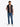 Man wearing a Tommy Hilfiger Packable Quilted Gilet, Black, pink shirt, blue jeans, and white shoes on a white background