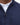 Close-up of a Barbour Tisbury Half Zip Jumper in Navy with subtle flecks, worn over a white collared shirt. The zipper pull features a circular ring, and the word 'BARBOUR' is embroidered on the chest.