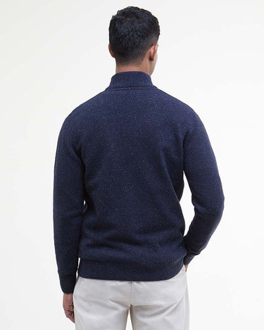 A man viewed from the back wearing a Barbour Tisbury Half Zip Jumper in Navy sweater and off-white trousers, set against a plain white studio background.