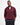 A man wearing a burgundy Barbour Tisbury Half Zip Jumper in Ruby over a white t-shirt and dark trousers, standing against a plain white studio background.
