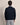 Man wearing a Bugatti V Neck Jumper, Navy over a striped shirt with a beige background