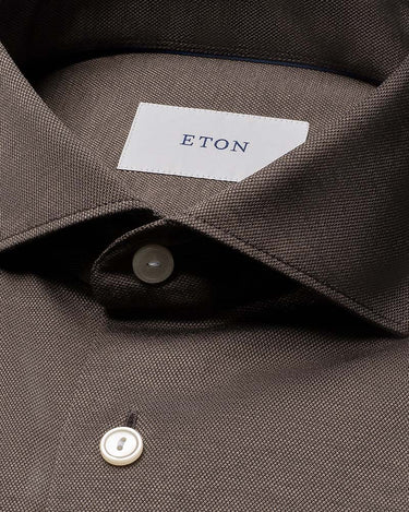 Close-up of a Eton Filo di Scozia Jersey Slim Fit Brown Shirt collar with a white neck label reading ETON and white buttons.