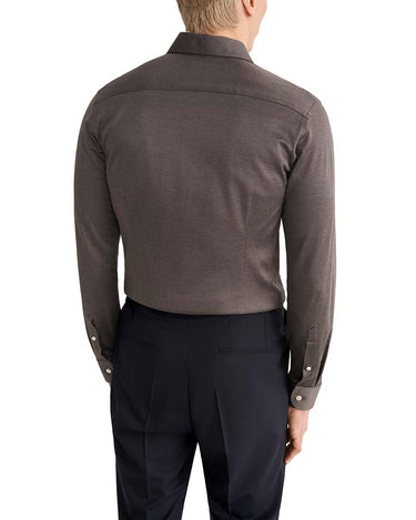 Rear view of a man wearing a Eton Filo di Scozia Jersey Slim Fit Brown Shirt tucked into dark navy trousers, against a plain white background.