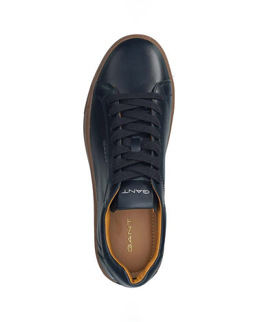 A top-down view of a GANT leather sneaker in navy blue, featuring dark navy laces, a brown gum sole, and a tan interior lining.