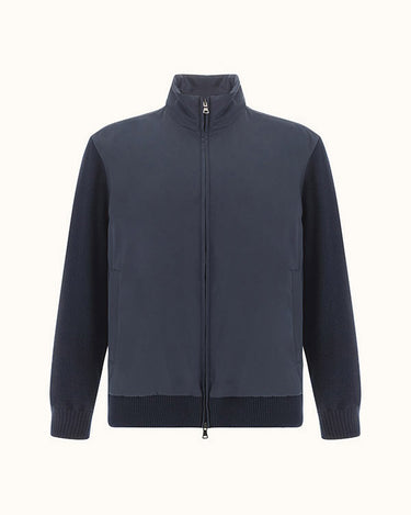 A Paul & Shark Typhoon Hybrid Zip Jacket, Bluewith a mock neck collar, solid front panel, and ribbed knit sleeves, cuffs, and hem, displayed on a clean off-white background.
