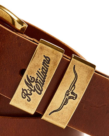 Close-up of a R.M. Williams Drover Belt, Caramel with a gold-toned rectangular buckle engraved with 'R.M.