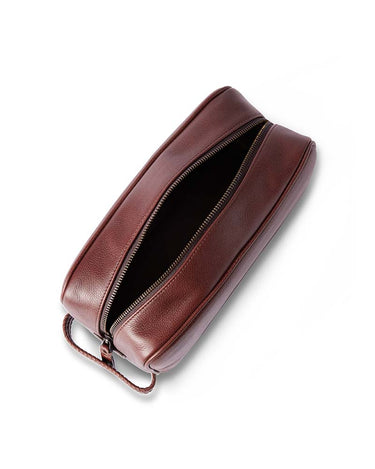 A R.M. Williams Farrier Washbag, Whiskey Brown with an open top and a small leather loop handle, shown on a clean white background.