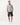 A man modeling a R.M. Williams Rod Pique Polo, Greywith dark navy shorts and white sneakers, standing against a plain white studio background.