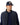 A man wearing a navy blue puffer vest over a matching navy long-sleeve shirt and a R.M. Williams Steerhead Trucker Cap, Navy with gold embroidered text, photographed against a plain white background.