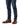 A close-up of a person's legs wearing dark blue slim-fit jeans and R. M. Williams Comfort Craftsman Boot Wide Fit, Brown against a white background.