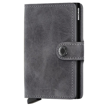 A vintage grey and black Secrid mini wallet with a snap closure.